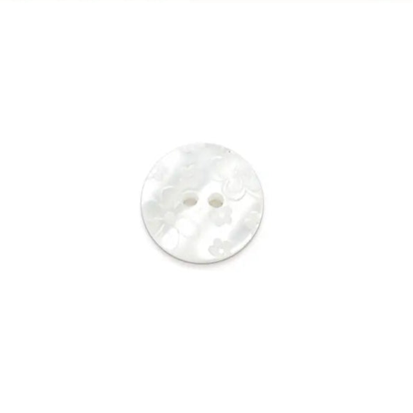 White button with engraved floral patterns on it.